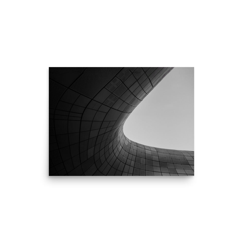 Photograph of a smooth round curve in a gray building facade, showcasing minimalist architecture and contemporary design.